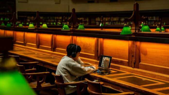 Student working on a laptop in a library, illustrating multilingual research access